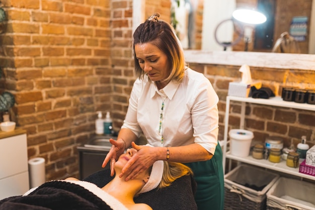 beautician giving gentle facial massage her blonde client beauty spa 609103 1400
